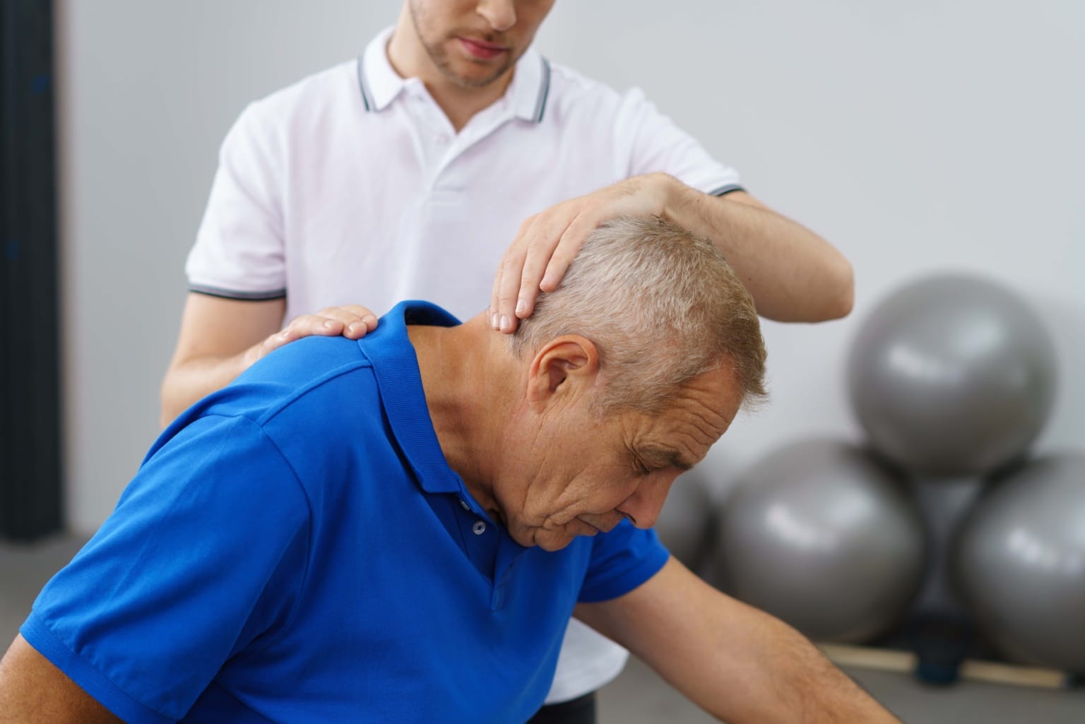 Physiotherapist,in,a,surgery,working,with,a,senior,patient,stretching