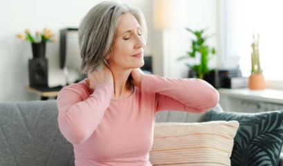 Sad,senior,woman,having,neck,pain,,sitting,at,sofa,at