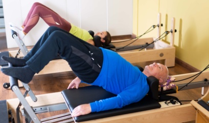 Older,man,doing,exercises,of,remedial,gymnastic,on,pilates,reformer